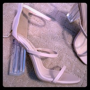 Strappy nude heels with a clear, chunk heel.